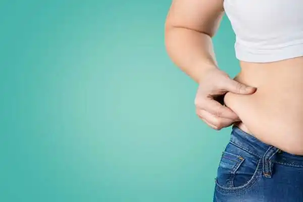 Image of woman pinching her love handles to show weight gain Thatcham